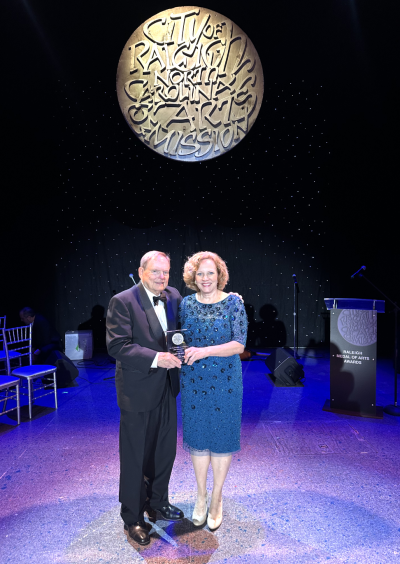 Jimmy Gilmore and Elizabeth Beilman holding award 