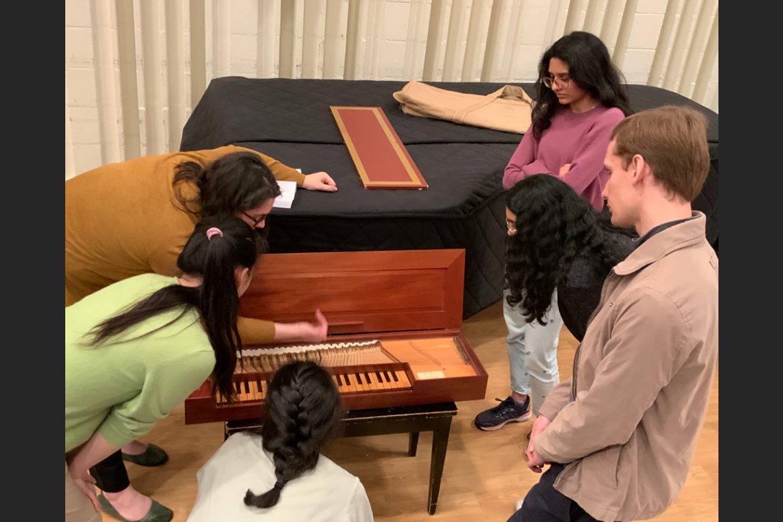 Students gathered around a clavichord